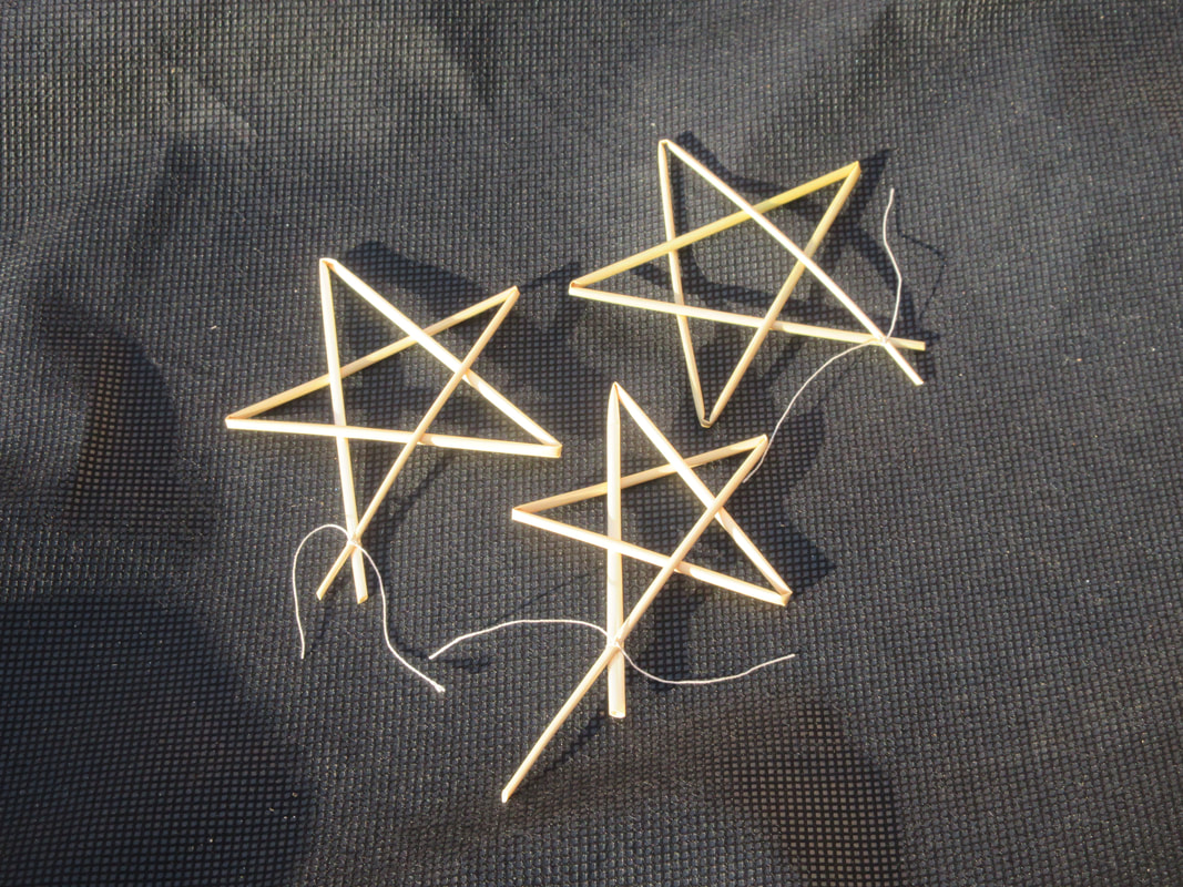 Three stars made of straw.  Each star has five points.  Each star is made from a single length of straw folded over itself.