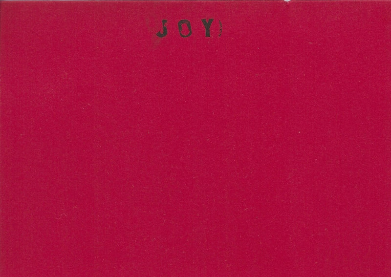 Scan of a red card with "Joy" written in the centre of the top.