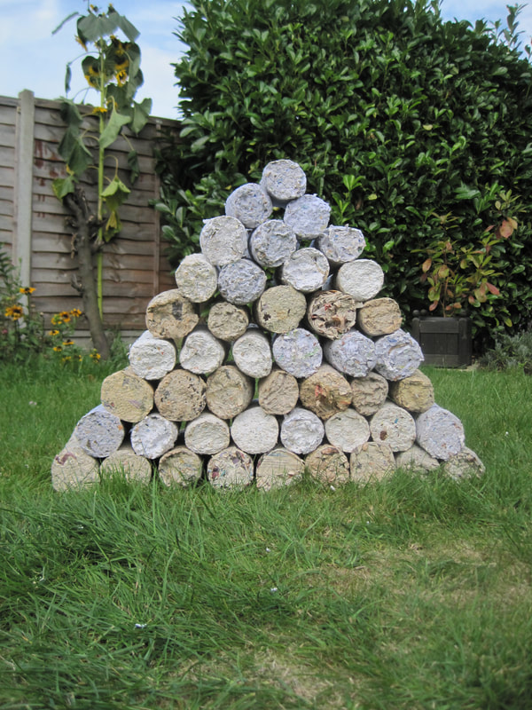 Pyramid of logs made from newspaper pulp.